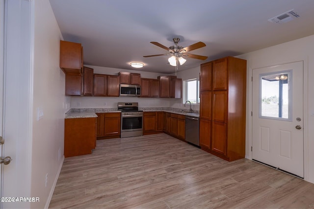 kitchen with ceiling fan, appliances with stainless steel finishes, light wood-type flooring, and a wealth of natural light