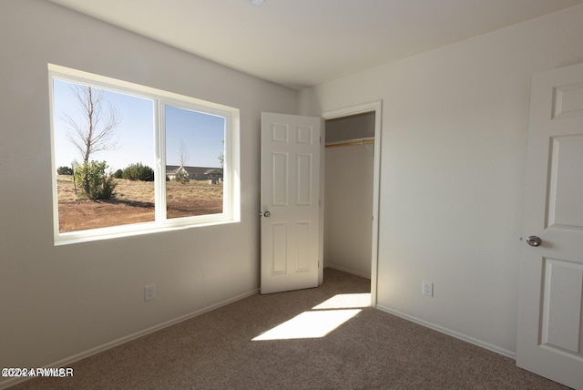 unfurnished bedroom featuring dark colored carpet and a closet