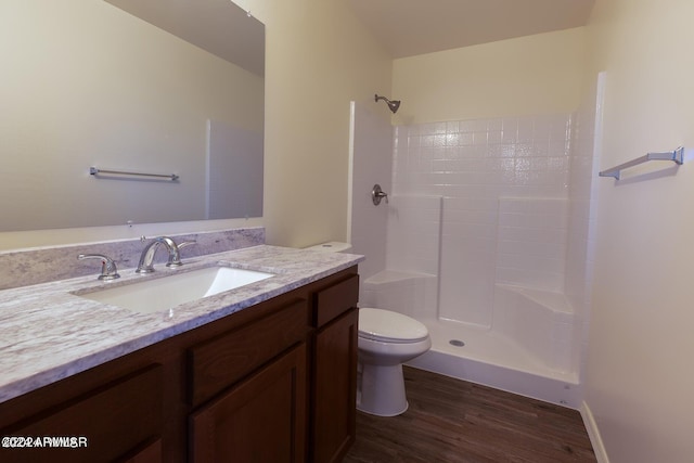 bathroom with walk in shower, hardwood / wood-style flooring, vanity, and toilet