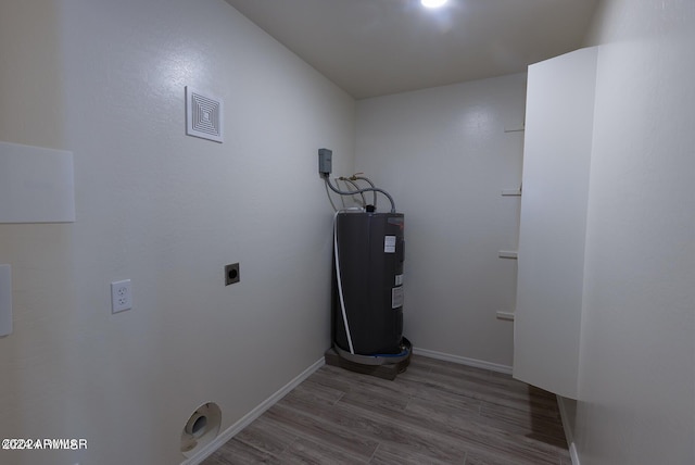 washroom featuring electric water heater, hardwood / wood-style flooring, and electric dryer hookup