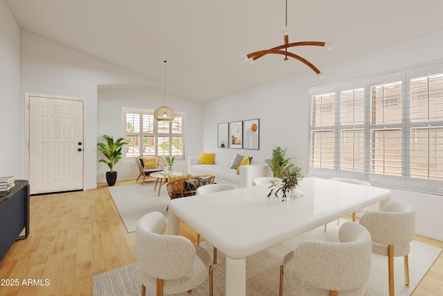 dining room with lofted ceiling and light hardwood / wood-style floors