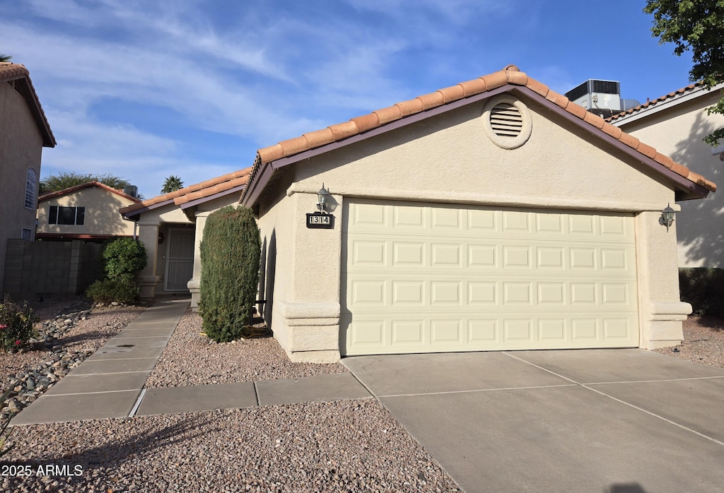 view of front of property featuring a garage and central air condition unit