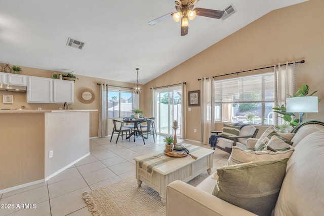 tiled living room with ceiling fan with notable chandelier, sink, and lofted ceiling