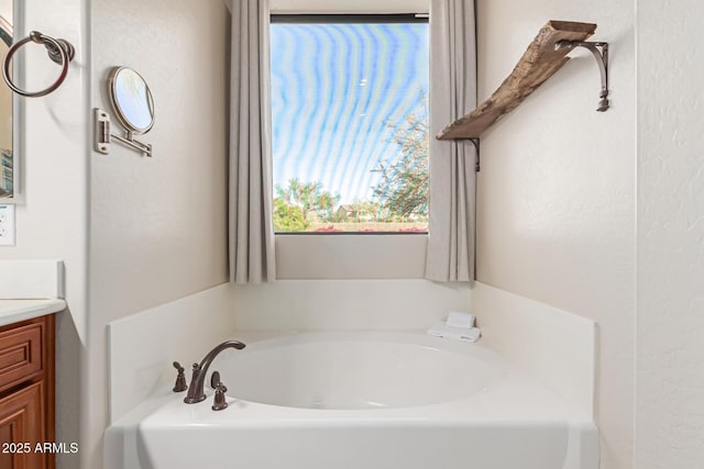 bathroom with vanity and a bath