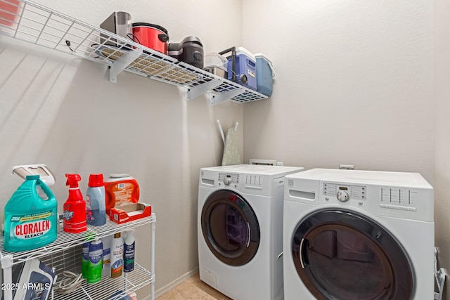 laundry area featuring light tile patterned floors and washing machine and clothes dryer