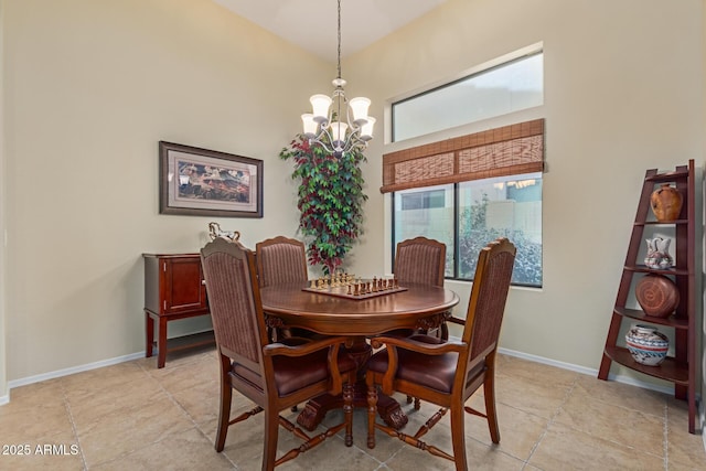 dining space with a towering ceiling, light tile patterned floors, and a notable chandelier