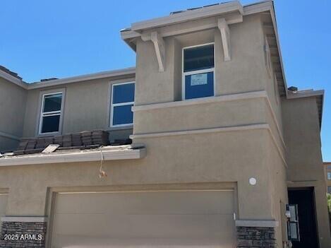 21228 N 58th St, Phoenix, AZ 85054 - view of side of home with an attached garage and stucco siding
