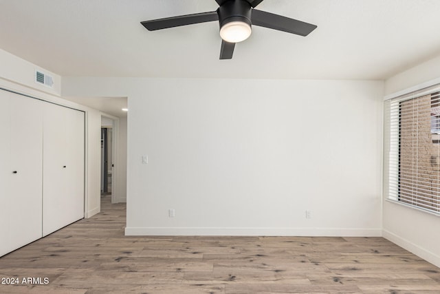 unfurnished bedroom featuring light hardwood / wood-style flooring, ceiling fan, and a closet