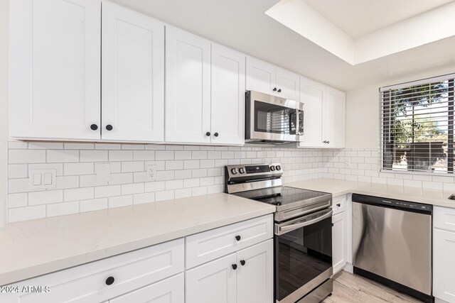 kitchen featuring white cabinets, light wood-type flooring, and appliances with stainless steel finishes