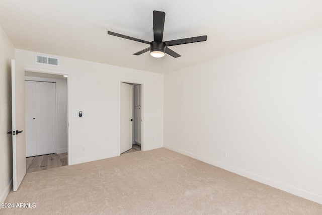 unfurnished room with light colored carpet and ceiling fan