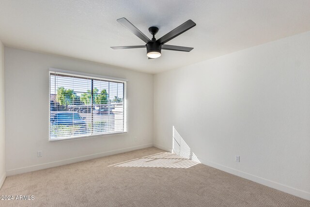 carpeted empty room featuring ceiling fan