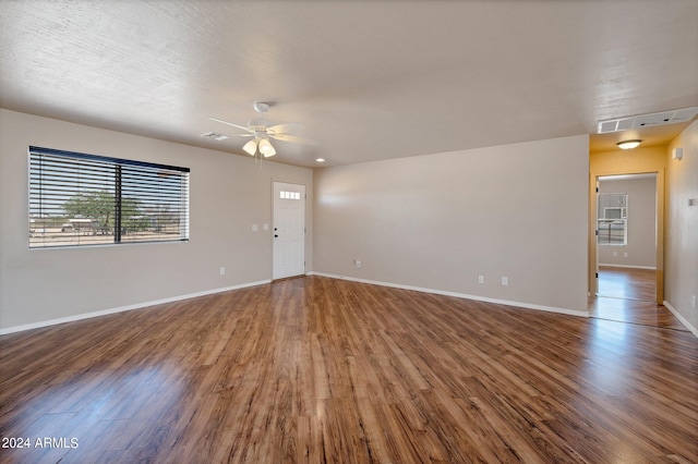 unfurnished living room featuring a textured ceiling, wood-type flooring, and ceiling fan