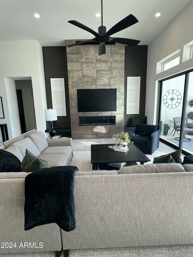 living room featuring ceiling fan and a large fireplace