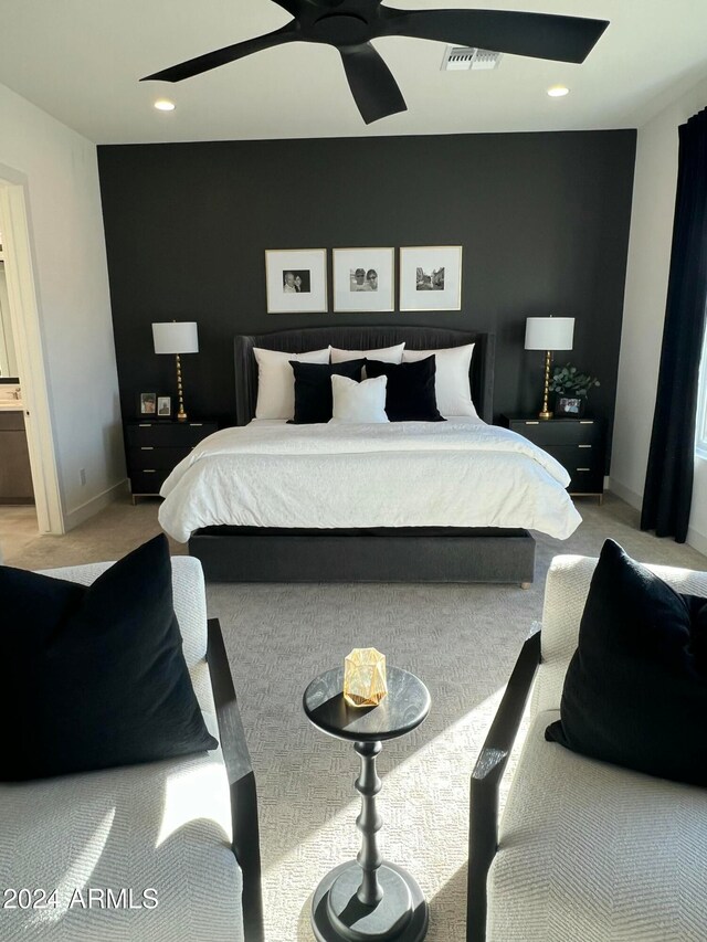 carpeted bedroom featuring ceiling fan and ensuite bath