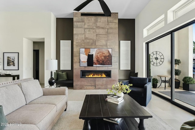 20475 E Indiana Ave, Queen Creek, AZ 85142 - living room featuring a fireplace, tile patterned flooring, and a high ceiling