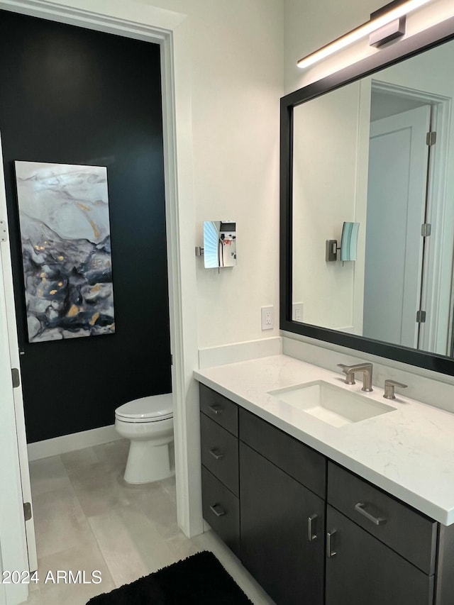 bathroom featuring tile patterned flooring, vanity, and toilet