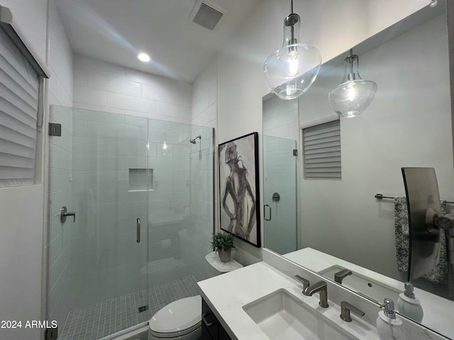 bathroom with vanity, toilet, and a shower with shower door