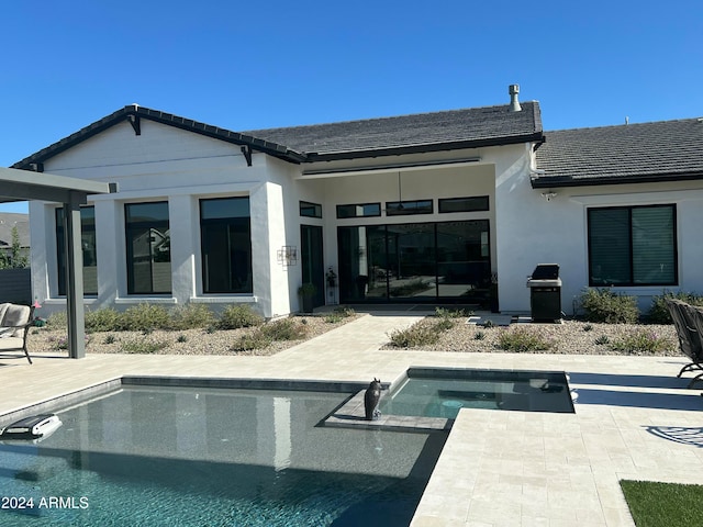 back of house with a patio and a pool with hot tub