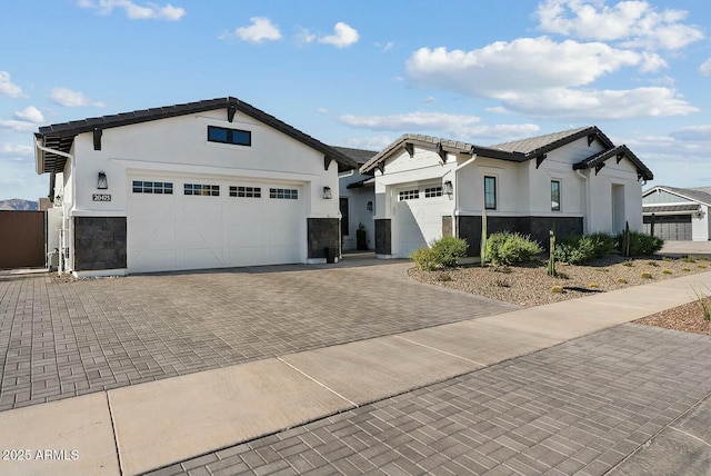 20475 E Indiana Ave, Queen Creek, AZ 85142 - view of front of home with stone siding, stucco siding, an attached garage, and decorative driveway