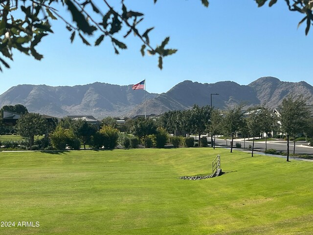 surrounding community featuring a lawn and a mountain view