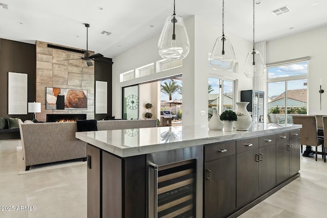 20475 E Indiana Ave, Queen Creek, AZ 85142 - kitchen with wine cooler, a spacious island, a towering ceiling, ceiling fan, and hanging light fixtures