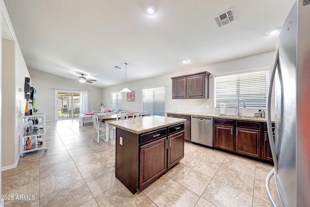 2716 W Sunland Ave, Phoenix, AZ 85041 - kitchen featuring appliances with stainless steel finishes, a sink, dark brown cabinetry, ceiling fan, and a center island