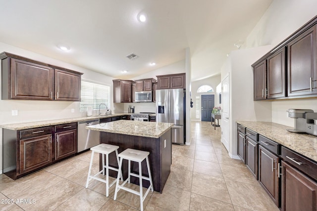 2716 W Sunland Ave, Phoenix, AZ 85041 - kitchen featuring appliances with stainless steel finishes, dark brown cabinets, a sink, a kitchen island, and lofted ceiling
