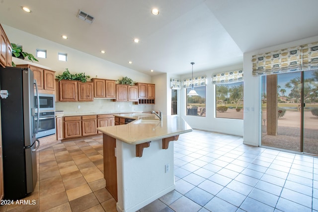 kitchen featuring light tile patterned flooring, a kitchen island with sink, a sink, light countertops, and appliances with stainless steel finishes