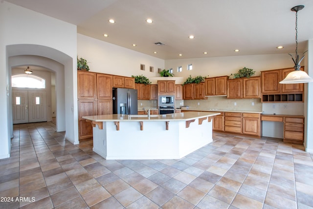 kitchen featuring built in microwave, oven, light countertops, and fridge with ice dispenser