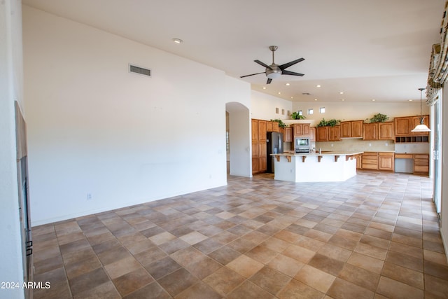 unfurnished living room featuring visible vents, high vaulted ceiling, recessed lighting, arched walkways, and ceiling fan