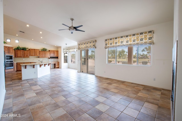 kitchen with open floor plan, plenty of natural light, light countertops, and vaulted ceiling