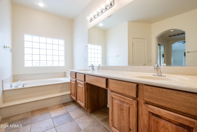 bathroom featuring a sink, a garden tub, double vanity, and tile patterned flooring