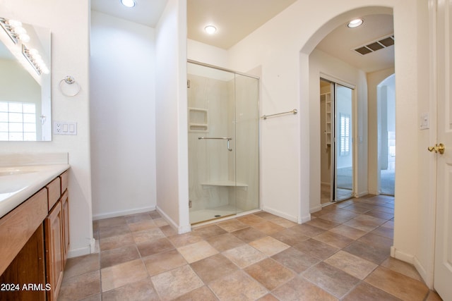 full bathroom featuring visible vents, baseboards, a stall shower, and vanity