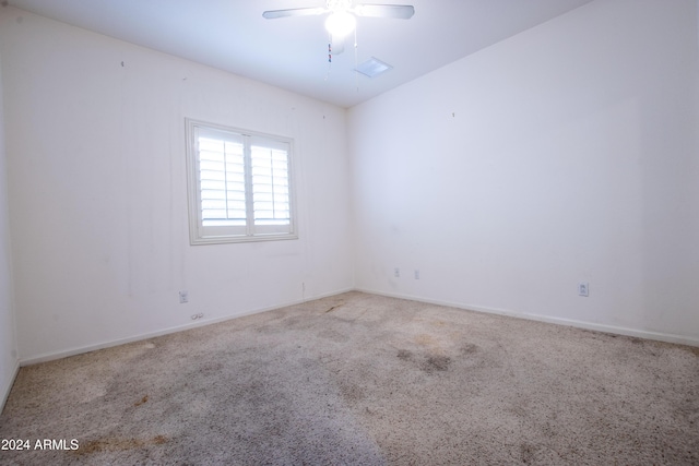 carpeted empty room featuring visible vents, baseboards, and ceiling fan