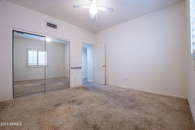 unfurnished bedroom featuring visible vents, a ceiling fan, a closet, carpet, and baseboards