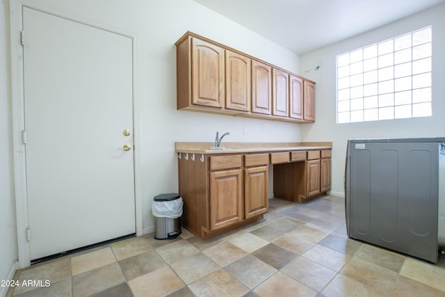 clothes washing area featuring washer / dryer, cabinet space, and a sink