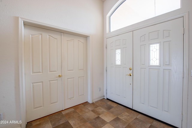 entrance foyer featuring a high ceiling and stone finish flooring