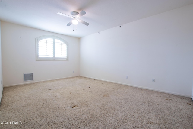 unfurnished room featuring visible vents, baseboards, a ceiling fan, and carpet flooring