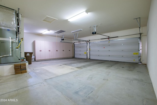 garage featuring heating unit and a garage door opener