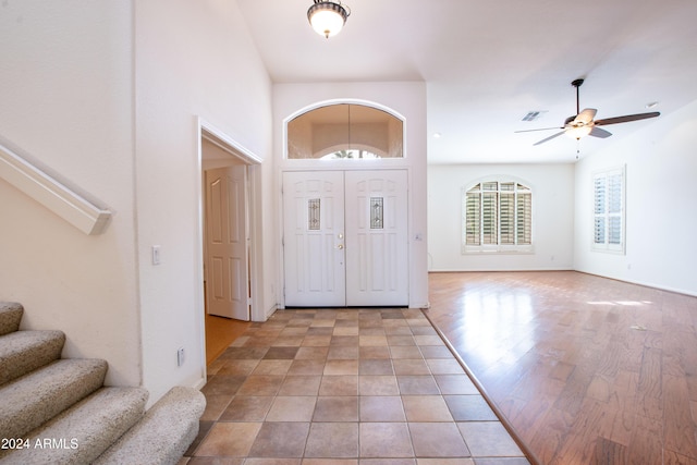 entryway with baseboards, visible vents, ceiling fan, stairs, and light wood-type flooring