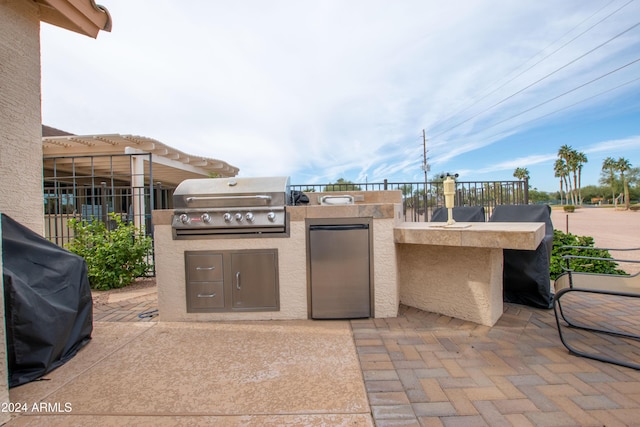 view of patio with an outdoor kitchen, fence, and grilling area