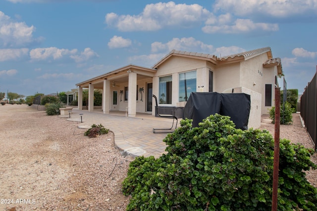 back of house with a patio area, a fenced backyard, and stucco siding