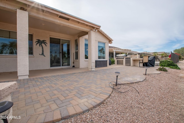 view of patio featuring exterior kitchen and fence