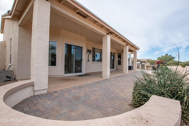 rear view of property featuring a patio and stucco siding