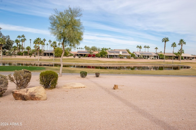 view of home's community featuring a lawn and a water view