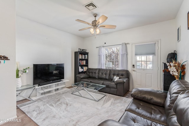 carpeted living room featuring ceiling fan and visible vents