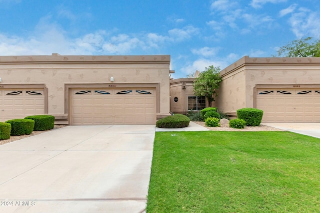 view of front of property with a garage and a front lawn