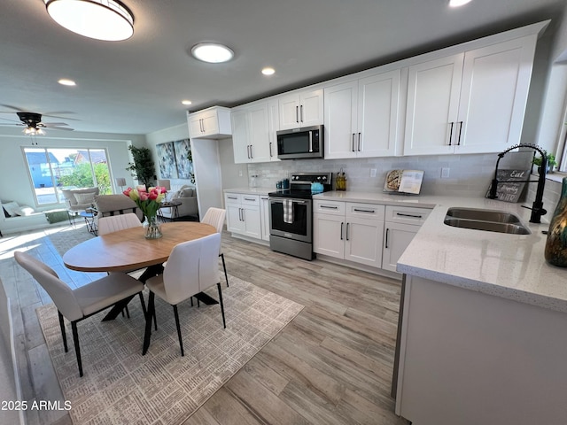 kitchen featuring backsplash, sink, white cabinetry, and stainless steel appliances