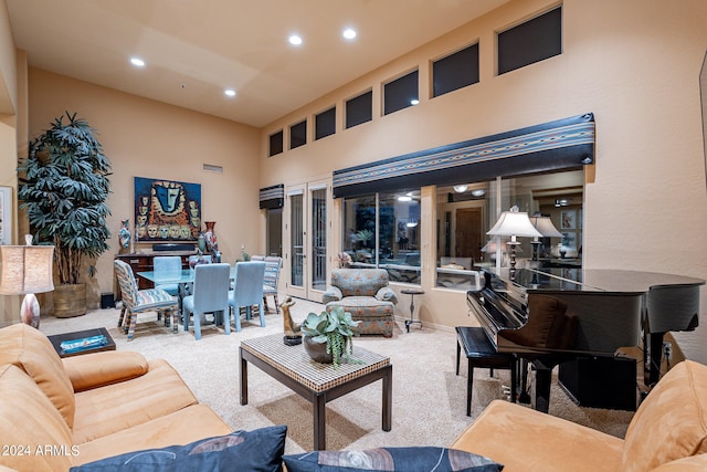 carpeted living room featuring a towering ceiling