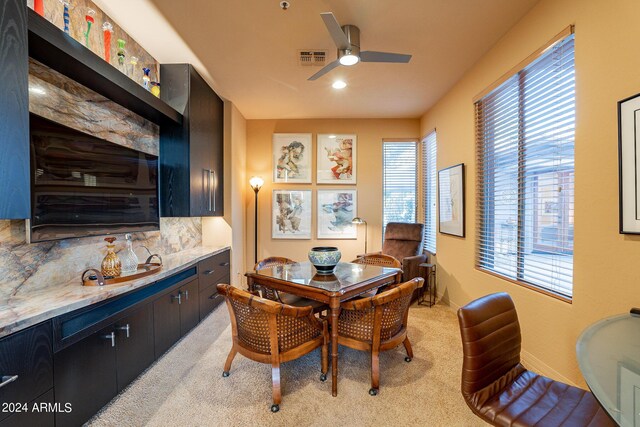 dining room featuring light carpet and ceiling fan